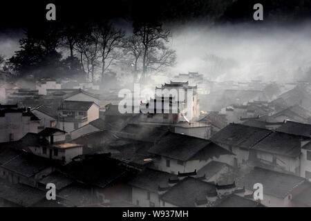 Bezaubernde Nebel teilweise deckt Häuser im Dorf, Shicheng Wuyuan County, Stadt Shangrao, East China Provinz Jiangxi, 17. Januar 2013. Stockfoto