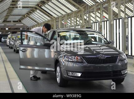 Ein chinesischer Arbeiter untersucht einen Skoda Auto auf der Montagelinie an die automatische Anlage von Shanghai Volkswagen, ein Joint Venture zwischen der SAIC und VW, in Yizheng, Stockfoto