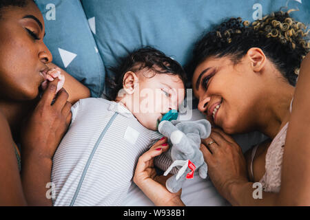 Hohe Betrachtungswinkel und der liebevolle Mütter Lügen mit niedlichen Sohn am Bett zu Hause Stockfoto