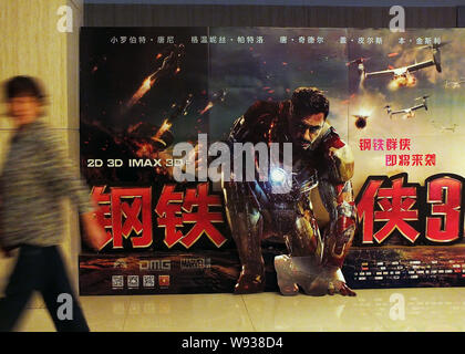 Eine Frau geht Vergangenheit ein Poster zum Film Iron Man 3 an einem Kino in Kunshan City, Central China Provinz Hubei, 1. Mai 2013. Iron Man 3 hat bekräftigt Ho Stockfoto