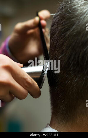 Friseur schneiden Mans grau Hören mit Clipper, Hände, Nahaufnahme Stockfoto