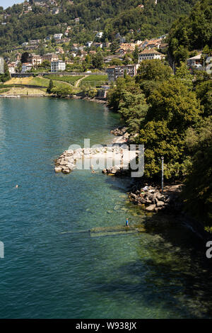 Blick auf den Strand neben dem Schloss Chillon (Chateau de Chillon) am Genfer See (Lac Leman) in Veytaux, Riviera-Pays-d'Enhaut, Waadt, Schweiz. Stockfoto