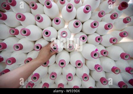 Ein weiblicher chinesischer Arbeiter übernimmt Produktion von Garn nach Südostasien in einer Textilfabrik in Stadt Huaibei, die exportiert werden sollen, East China Provinz Anhui, 15. Stockfoto