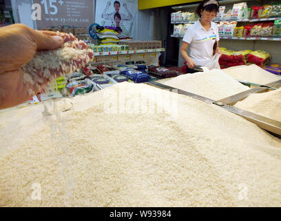 ------ Chinesische Kunden Reis in einem Supermarkt in Yichang kaufen, Zentrale China Provinz Hubei, 13. September 2013. Der International Grains Council r Stockfoto