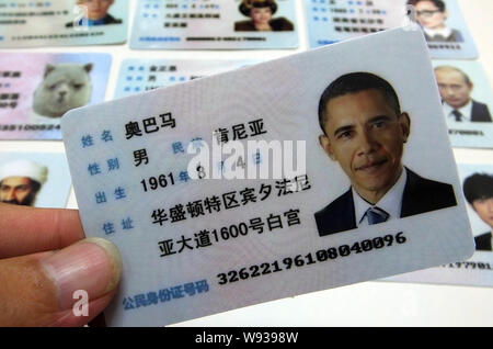 Ein Mann zeigt eine gefälschte Chinesischen ID-Karte von US-Präsident Barack Obama zum Verkauf an einen Stand auf einer Straße in Guangzhou City, South China Guangdong Provinz, Stockfoto