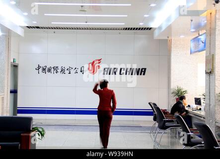 ---- Ein chinesischer Mitarbeiter an einem Namensschild von Air China im Ticket Lobby in Peking, China, 22. Februar 2011. Festland Airlines erfahrenen Stockfoto