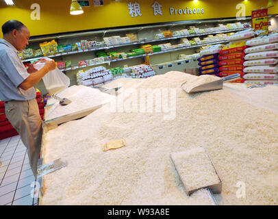 ------ Chinesische Kunden Reis in einem Supermarkt in Yichang kaufen, Zentrale China Provinz Hubei, 13. September 2013. Der International Grains Council r Stockfoto