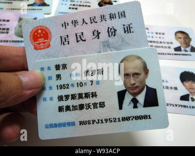 Ein Mann zeigt eine gefälschte Chinesischen ID-Karte des russischen Präsidenten Wladimir Putin zum Verkauf an einen Stand auf einer Straße in Guangzhou City, South China Guangdong provi Stockfoto