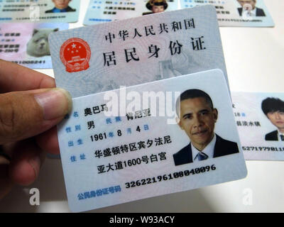 Ein Mann zeigt eine gefälschte Chinesischen ID-Karte von US-Präsident Barack Obama zum Verkauf an einen Stand auf einer Straße in Guangzhou City, South China Guangdong Provinz, Stockfoto