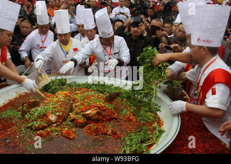 Chinesische Köche kochen eine riesige Schüssel, gedünsteter Fisch Kopf mit gewürfelte Peperoni während der 23 chinesischen Koch Festival in Changsha, China Hunan pr Stockfoto
