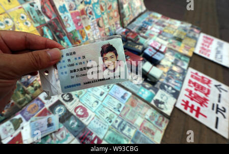 Ein Mann zeigt eine gefälschte Chinesischen ID-Karte von Hongkong Sänger und Schauspieler Edison Chen zum Verkauf an einen Stand auf einer Straße in Guangzhou City, South China Guangdong Stockfoto