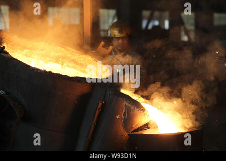 ---- Ein chinesischer Arbeiter Uhren geschmolzenen Stahl in eine Form in einer Gießerei in Nantong City, East China Jiangsu Provinz, 13. November 2013. Stockfoto