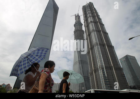 Fußgänger vorbei an die Spitze-out Shanghai Tower, Center, das Shanghai World Financial Center, Links und Jinmao Tower, rechts, in der Lujiazui Finanz Stockfoto