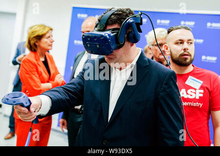Ludwigshafen, Deutschland. 12 Aug, 2019. Hubertus Heil (SPD), Bundesminister für Arbeit und Soziales, und ein Auszubildender aus der Chemiekonzern BASF, die Funktionalität von Virtual reality Brillen versuchen. Hinter ihm ist Malu Dreyer (l, SPD), Ministerpräsident von Rheinland-Pfalz. Der Sekretär der Arbeit ist auf einer Sommerreise. Foto: Uwe Anspach/dpa/Alamy leben Nachrichten Stockfoto