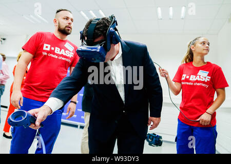 Ludwigshafen, Deutschland. 12 Aug, 2019. Hubertus Heil (SPD), Bundesminister für Arbeit und Soziales, ist Sie die Funktionalität von Virtual reality Brillen mit Praktikanten aus der Chemiekonzern BASF. Der Sekretär der Arbeit ist auf einer Sommerreise. Foto: Uwe Anspach/dpa/Alamy leben Nachrichten Stockfoto