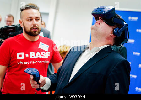 Ludwigshafen, Deutschland. 12 Aug, 2019. Hubertus Heil (SPD), Bundesminister für Arbeit und Soziales, die versucht, die Funktionalität der virtuellen Realität Gläser mit einem Trainee bei der Chemiekonzern BASF. Der Sekretär der Arbeit ist auf einer Sommerreise. Foto: Uwe Anspach/dpa/Alamy leben Nachrichten Stockfoto