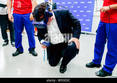Ludwigshafen, Deutschland. 12 Aug, 2019. Hubertus Heil (SPD), Bundesminister für Arbeit und Soziales, ist Sie die Funktionalität von Virtual reality Brillen mit Praktikanten aus der Chemiekonzern BASF. Der Sekretär der Arbeit ist auf einer Sommerreise. Foto: Uwe Anspach/dpa/Alamy leben Nachrichten Stockfoto