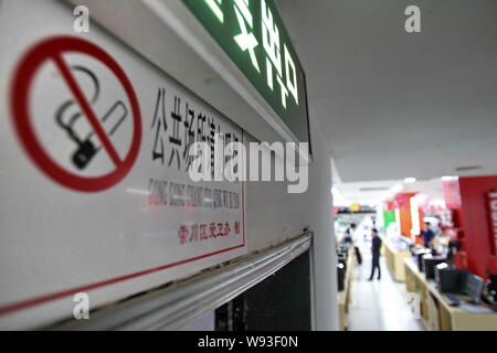 ------ Chinesische Kunden vorbei ein Rauchverbot Schild an einer Mall in Nantong City, East China Jiangsu Provinz, 30. April 2011. China Tabak regulat Stockfoto