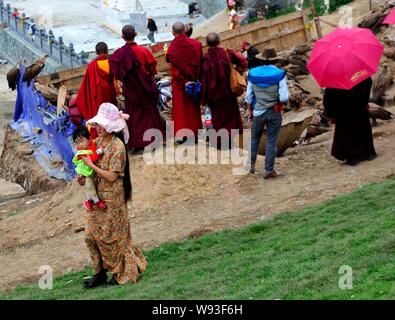 Lokale Lamas und Touristen Blick auf eine Herde von Geier nach einem Himmel Beerdigung in Sertar County, Ganzi tibetischen autonomen Präfektur, Southwest China Sichua Stockfoto