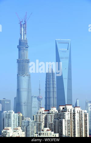 Die überstieg-out Shanghai Tower ist im Bau, links, neben dem Shanghai World Financial Center, rechts, und Jinmao Tower, zweite rechts, in der Stockfoto