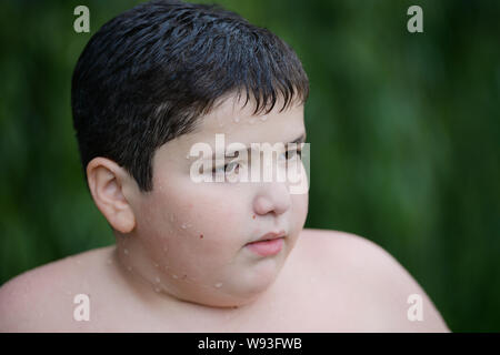 Closeup Portrait von kleinen Fat Boy auf grünen Hintergrund Outdoor Freizeitaktivitäten Stockfoto