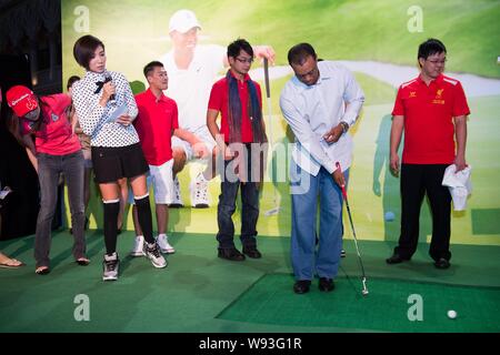 Golfspieler Tiger Woods der Vereinigten Staaten, vorne rechts, T-Stücke mit einer Hand während einer Fan Meeting Veranstaltung in Macau, China, 29. Oktober 2013. Stockfoto