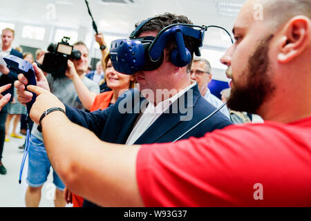 Ludwigshafen, Deutschland. 12 Aug, 2019. Hubertus Heil (SPD), Bundesminister für Arbeit und Soziales, ist Sie die Funktionalität von Virtual reality Brillen mit einem Trainee bei der Chemiekonzern BASF. Hinter ihm ist Malu Dreyer (l, SPD), Ministerpräsident von Rheinland-Pfalz. Der Sekretär der Arbeit ist auf einer Sommerreise. Foto: Uwe Anspach/dpa/Alamy leben Nachrichten Stockfoto