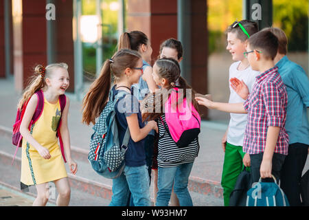 Mitschüler zur Schule gehen. Studenten begrüßen sich. Stockfoto