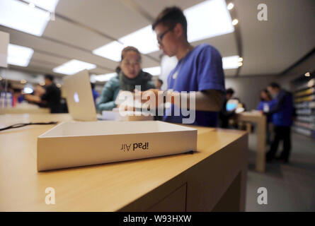 Chinesische Mitarbeiter unterstützen Kunden iPad Tablet-PC in einem Apple Store in Peking, China, 1. November 2013 zu kaufen. Apple Inc. mit seinem neuen iPad Stockfoto