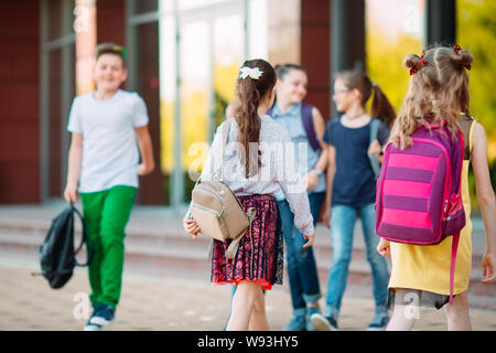 Mitschüler zur Schule gehen. Studenten begrüßen sich. Stockfoto