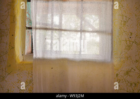 Details von einem alten Dorf Haus Fenster mit bestickten Vorhang. Stockfoto