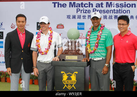 Rory McIlroy von Nordirland, die zweite Straße links, und Tiger Woods der Vereinigten Staaten, zweite rechts, Pose mit der Champion Trophy bei der Preisverleihung Stockfoto