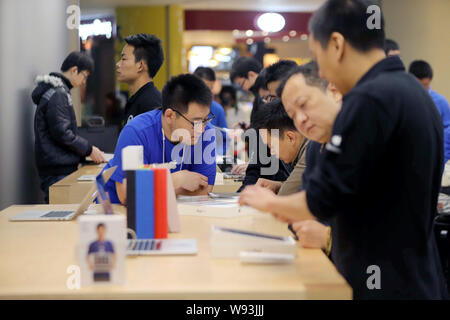 Chinesische Mitarbeiter unterstützen Kunden iPad Tablet-PC in einem Apple Store in Peking, China, 1. November 2013 zu kaufen. Apple Inc. mit seinem neuen iPad Stockfoto