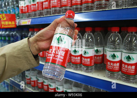 ---- Ein chinesischer Kunde kauft Flaschen Nongfu Quellwasser in einem Supermarkt in Sanmenxia, Zentrale China Provinz Henan, 7. Mai 2013. Nongfu Spri Stockfoto