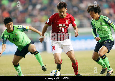 Gao Lin China Guangzhou Evergrande, Mitte, Herausforderungen Jeon Kwang-hwan, rechts, und Lim Sie-hwan Südkoreas Jeonbuk Hyundai Motors während thei Stockfoto