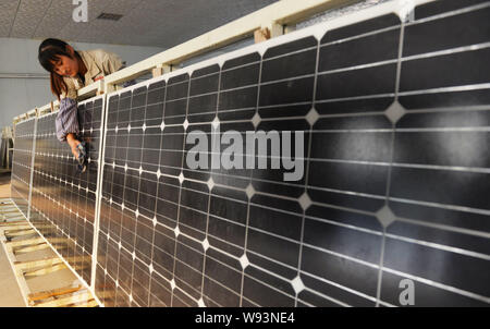 ---- Ein chinesischer Arbeiter Stäube aus Solarzellen im Werk von Shandong Hilight Solar Co., Ltd. in Zouping County, Binzhou Stadt, Ostchina Shando Stockfoto