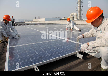 ------ Chinesische Arbeiter installieren Solaranlagen auf dem Dach des Fabrikgebäudes der Zhejiang Jinbei Wissenschaft und Technology Co., Ltd. in Tonglu Stadt, Ea Stockfoto