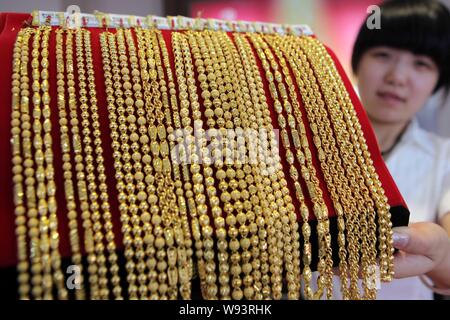 ---- Eine chinesische Angestellte zeigt Gold Halsketten an einem gold Shop in Ganyu, East China Jiangsu Provinz, 12. Juli 2013. China gold Verbrauch sprang 54 Stockfoto