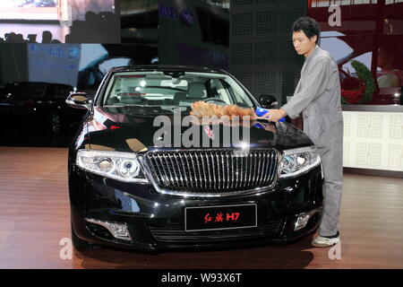 ---- Ein chinesischer Arbeiter Stäube aus eine rote Flagge (hongqi) H7 Limousine von FAW bei der Auto Show in Changchun, im Nordosten Chinas in der Provinz Jilin, 15. Stockfoto