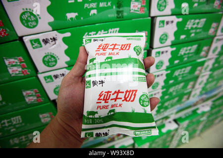 ---- Ein Kunde kauft eine Tasche von Mengniu reine Milch in einem Supermarkt in Shanghai, China, 23. August 2012. Chinesisches Milchpulver Entscheidungsträger, einschließlich das Innere Stockfoto