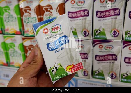 --FILE - ein chinesischer Kunde Geschäfte für Yili reine Milch in einem Supermarkt in Lanzhou, China Jiangsu Provinz, 9. Juli 2012. Bis zu 60 % der mil Stockfoto