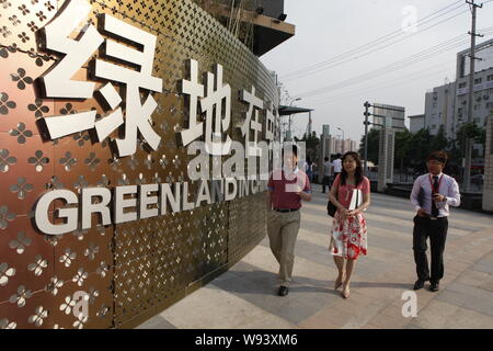 ---- Fußgänger vorbei an einem Namensschild von Grönland in Shanghai, China, 14. Mai 2011. Chinesischen staatseigenen Konglomeraten Grönland Holding Group ist Stockfoto