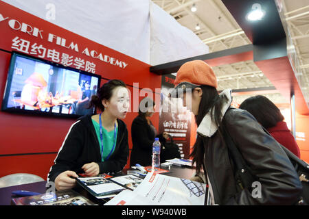 Eine Ausbildung Berater von der New York Film Academy von den Vereinigten Staaten, Links, im Gespräch mit einem Besucher während des 18. China International Education- Stockfoto