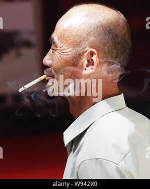 --FILE - Ein chinesischer Mann raucht eine Zigarette an einem öffentlichen Ort in Kunshan, China Provinz Hubei, 15. September 2013. Chinas Bemühungen gegen das Rauchen Stockfoto