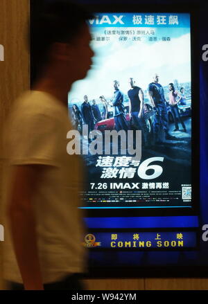 ---- Eine chinesische Kinogänger Spaziergänge hinter einem Plakat des IMAX-Edition des Films, Fast & Furious 6, in einem Kino in Kunshan City, Central China Hubei Stockfoto