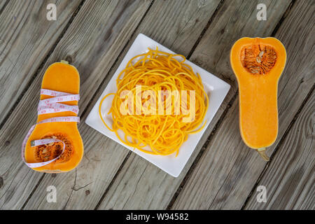 Blick von oben auf die butternut squash Nudeln mit Maßband - gesund vegan Pasta. Glutenfreie Gemüse Nudeln sind eine neue trendige Gesundheit Nahrung für niedrige Auto Stockfoto