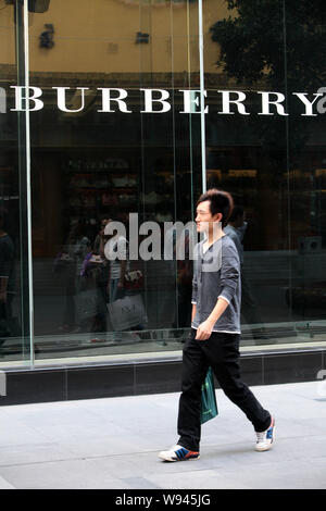 Ein Fußgänger geht hinter einem Burberry Store in Shanghai, China, 17. September 2012. Stockfoto