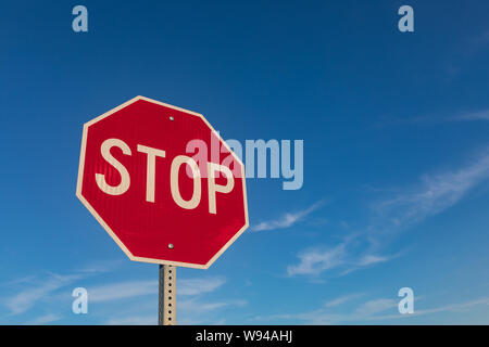 Isolierte closeup zu Rot reflektierende Stop-Schild mit blauem Himmel und weißen Wolken im Hintergrund Stockfoto