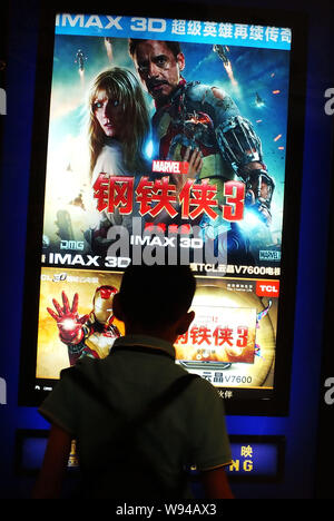 Ein chinesischer Junge schaut auf ein Poster zum Film Iron Man 3 an einem Kino in Kunshan City, Central China Provinz Hubei, 1. Mai 2013. Iron Man 3 hat reasserte Stockfoto