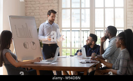 Schweren männlichen Trainer geben Flipchart Präsentation auf diverse Mitarbeiter Stockfoto